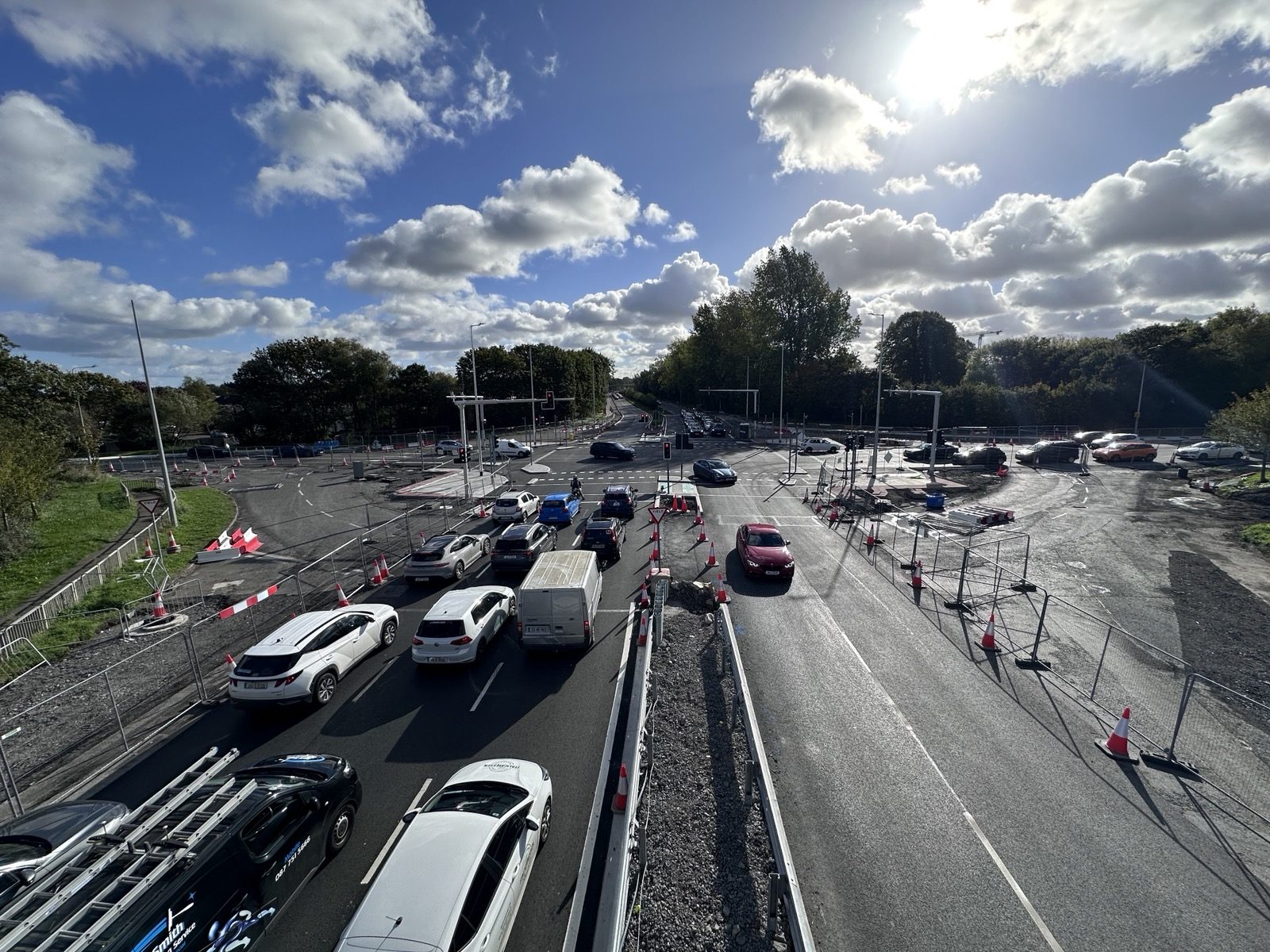 Looking along the R132 at the Estuary junction in Swords from above, with traffic queuing on the approach lanes under cones and barriers